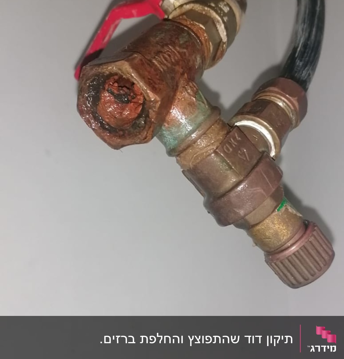 שסתום מתכת חלוד עם ידית אדומה